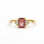 Gold ring with a pink gemstone on a white background