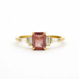 Gold ring with a pink gemstone on a white background