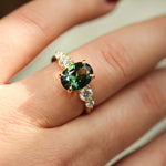 hand wearing large 2ct green sapphire ring with 4 diamonds