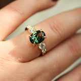 hand wearing large 2ct green sapphire ring with 4 diamonds
