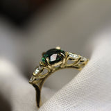 side view of wedfit high set sapphire ring with diamonds in blurred white fabric