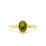 bezel set engagement ring with green yellow sapphire and satin finish on a white background