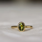 Bezel Solitaire Green/Yellow Sapphire Engagement Ring with Satin Finish on a neutral fabric