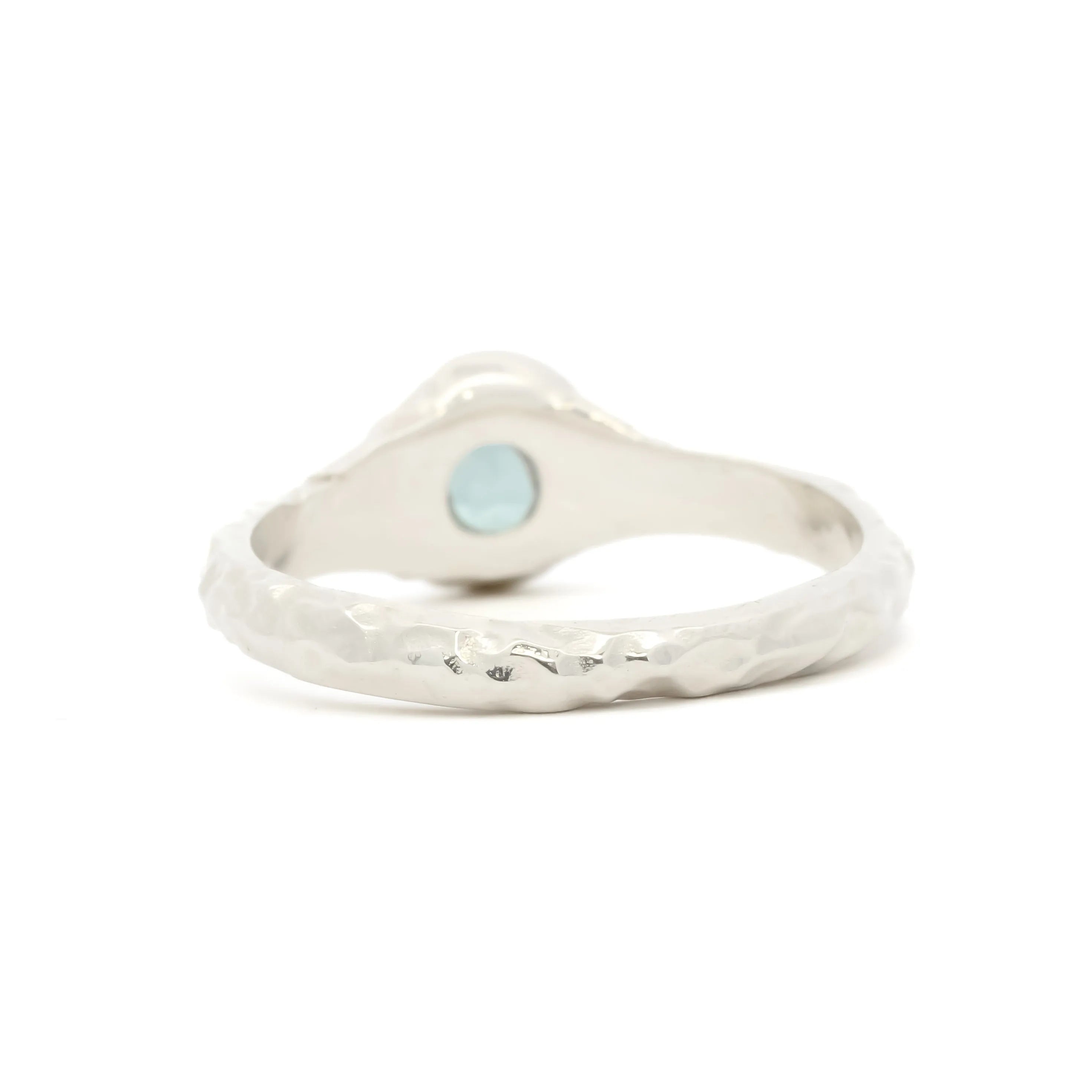 back view of Solitaire Blue Sapphire Molten Organic Engagement Ring on a white surface