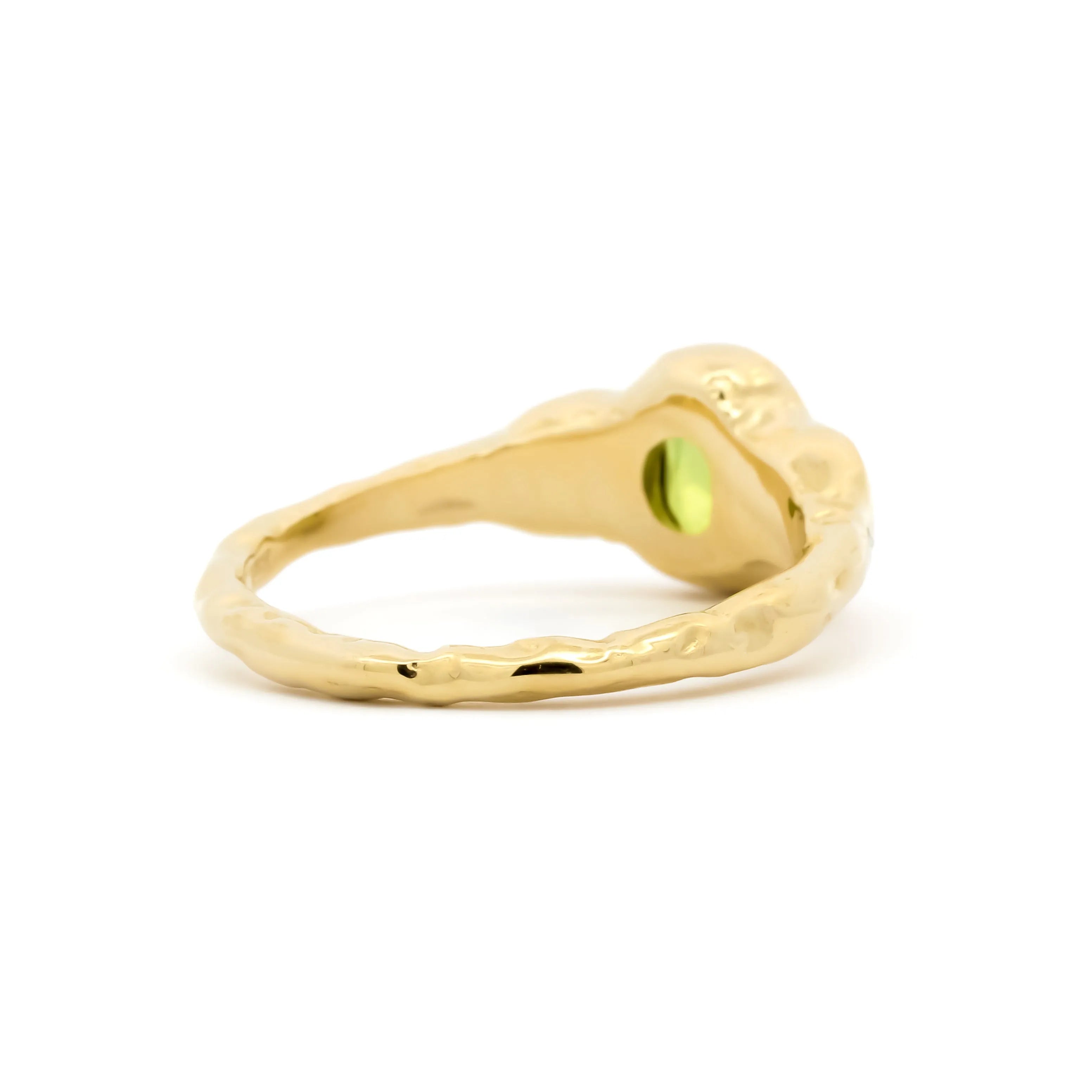 Gold ring with a green gemstone on a white background
