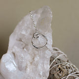 silver circle bracelet on crystal with sage in background