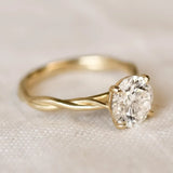 Gold ring with a diamond on a beige fabric background