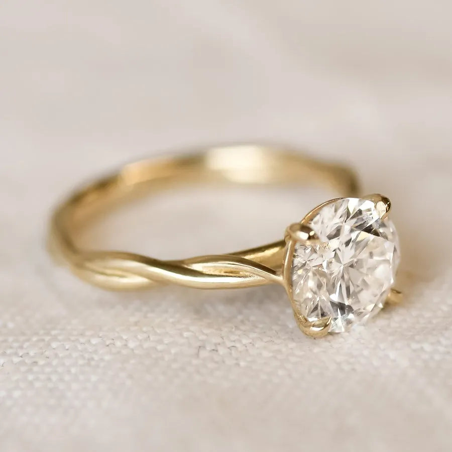 Gold ring with a diamond on a beige fabric background