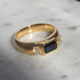 chunky gold bespoke ring with emerald cut sapphire and round diamonds 