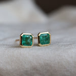 bespoke gold with green gemstones on a neutral background