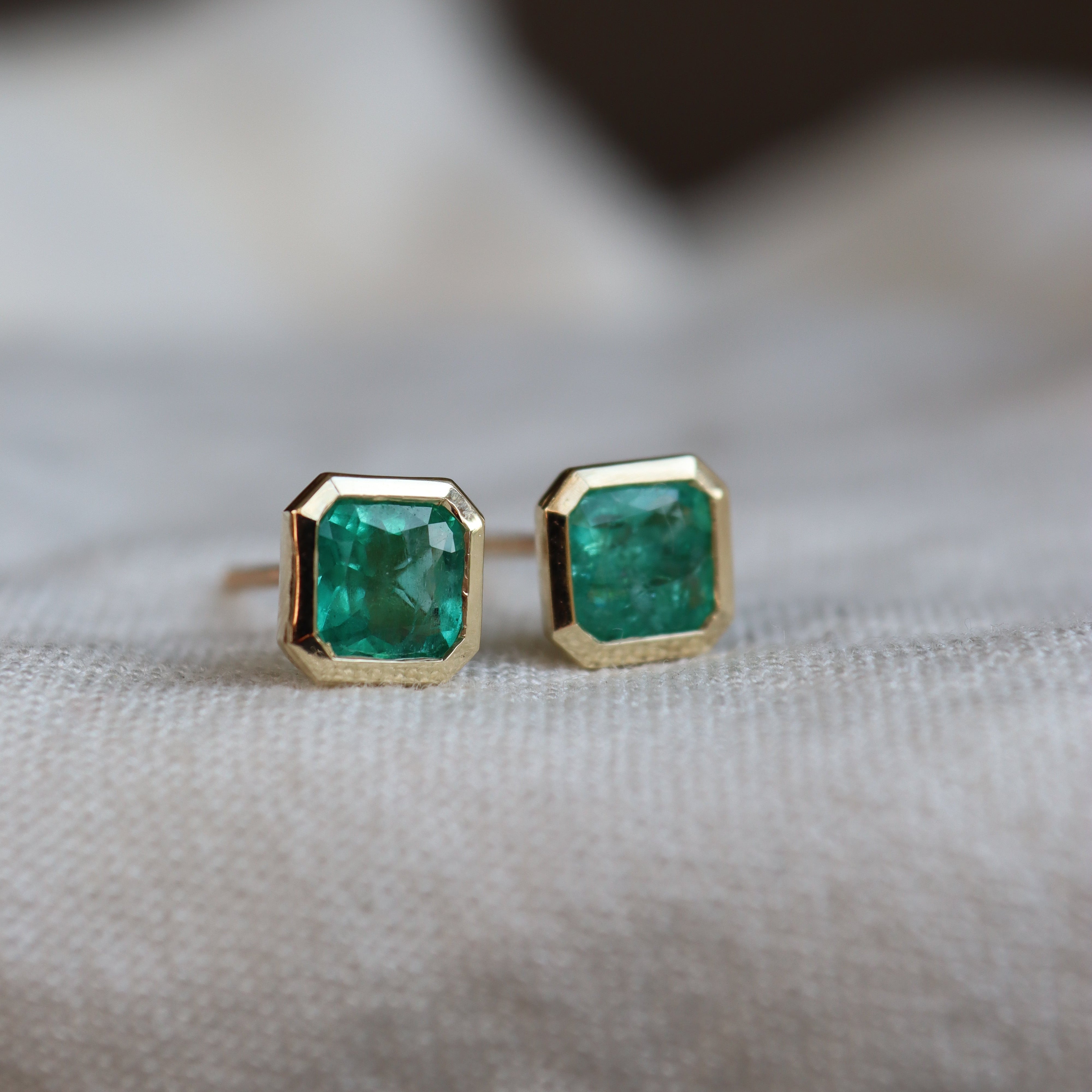 bespoke gold with green gemstones on a neutral background