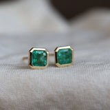 bespoke gold with green gemstones on a neutral background