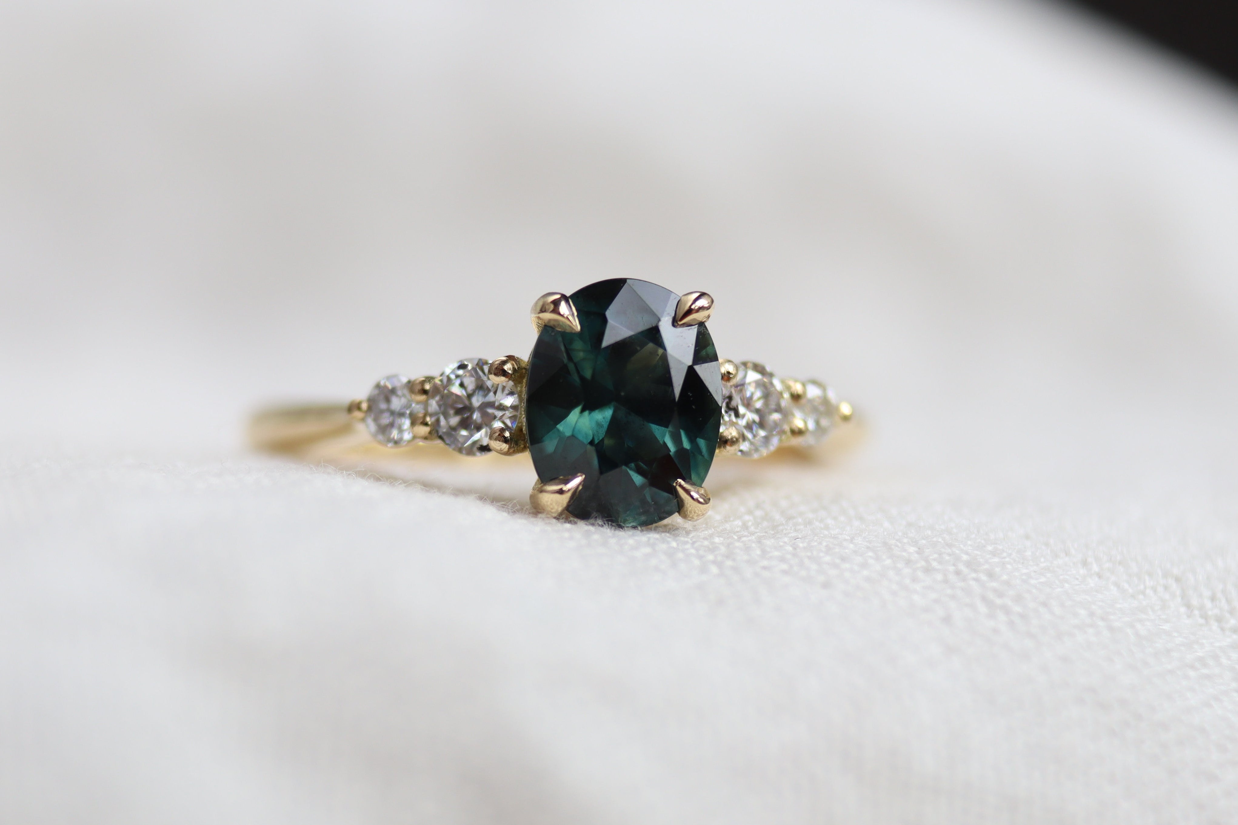 Gold ring with a green gemstone on a white background