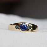 Gold ring with blue gemstones on a white background