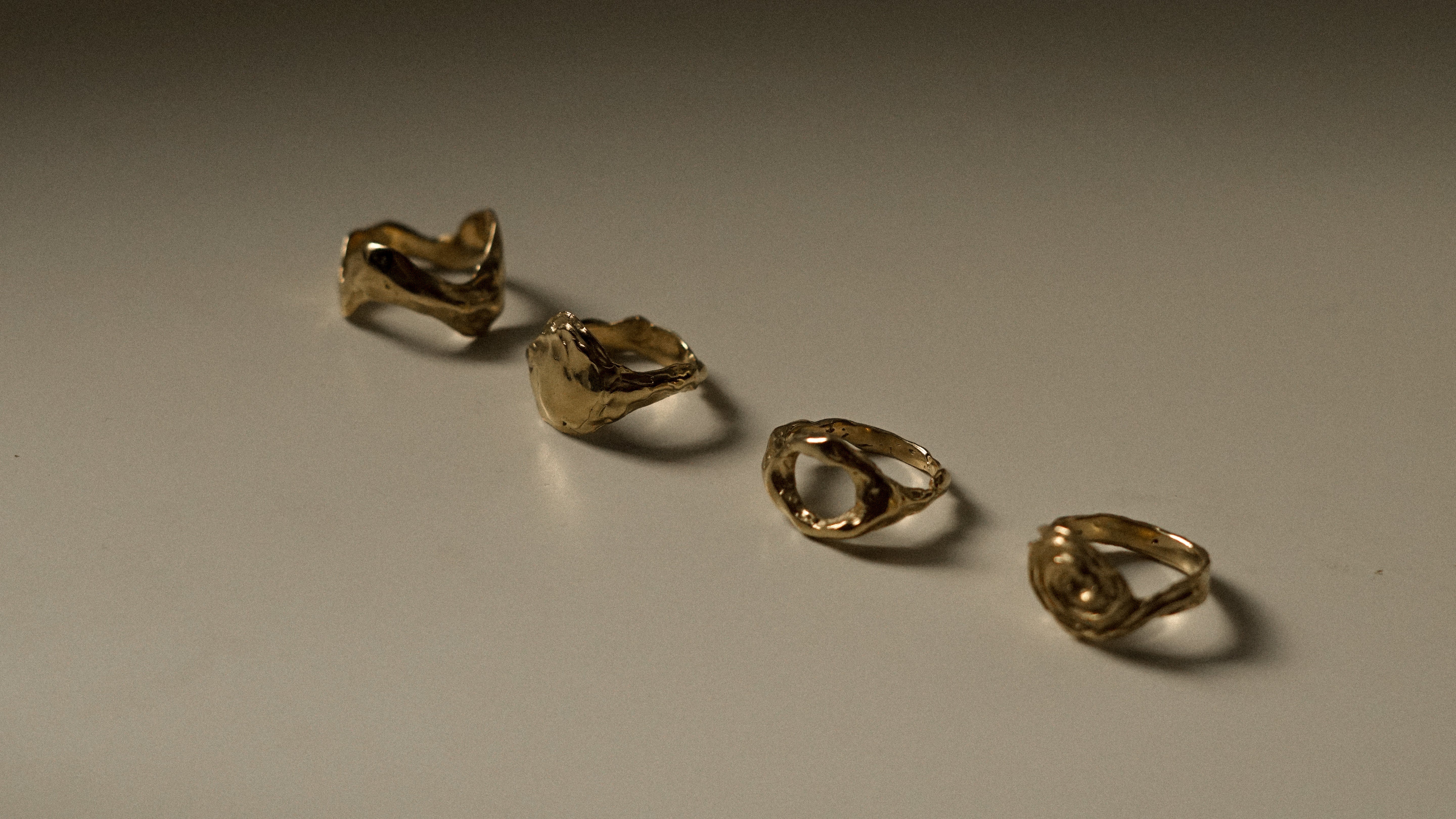 Four gold rings on a gray surface
