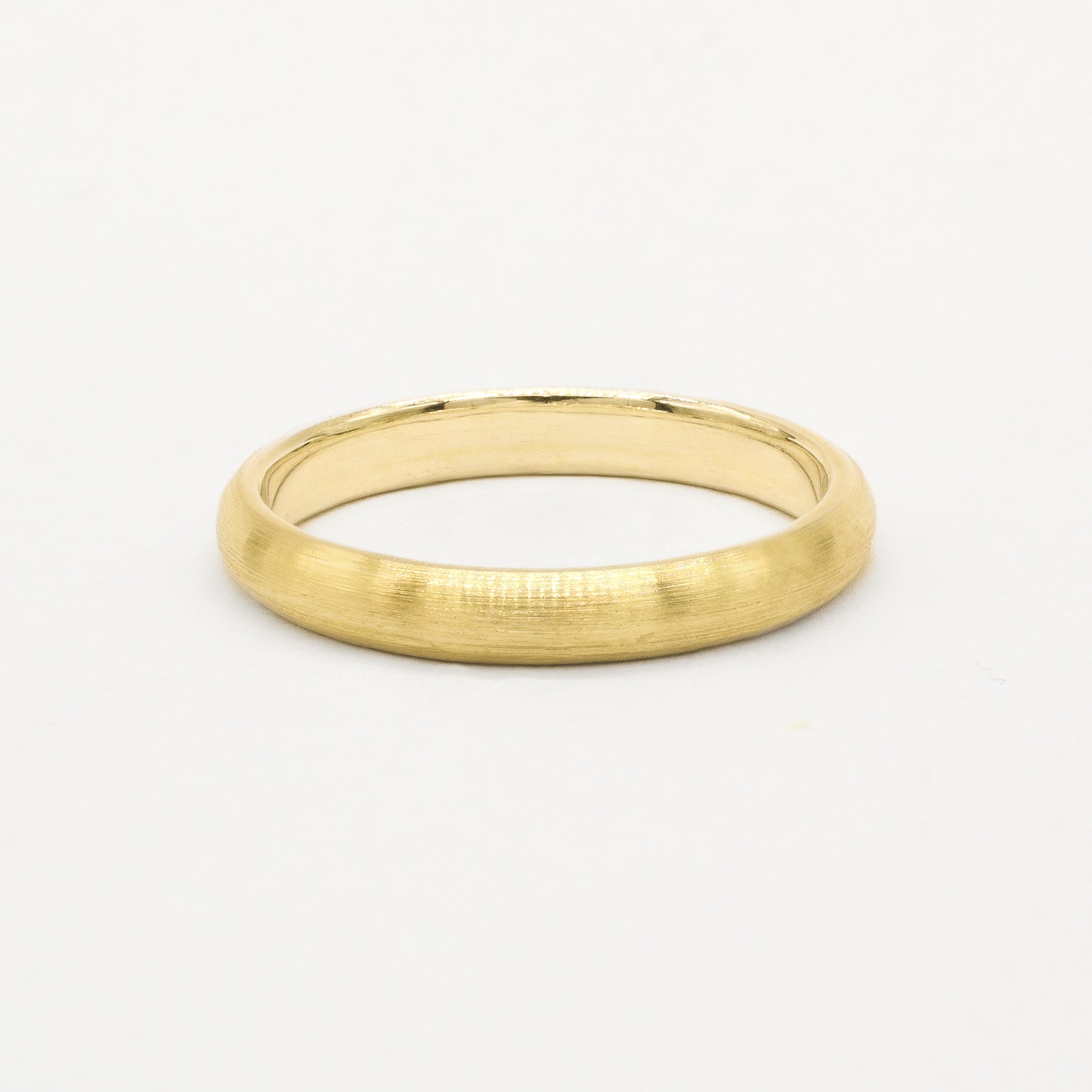Gold 3mm brushed wedding ring on a white background