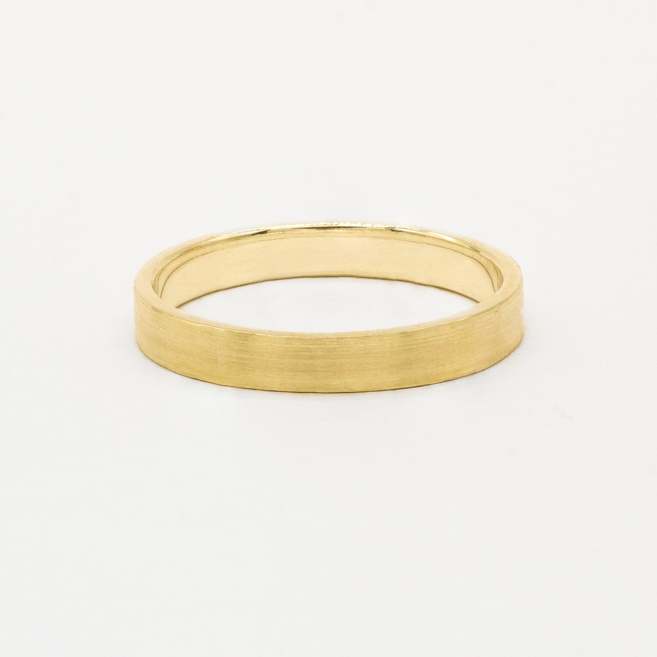 Gold brushed wedding ring in flat shape on a white background