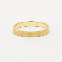 Gold brushed wedding ring in flat shape on a white background