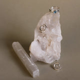 crystals with spiral silver earrings and silver blue topaz ring with beige background