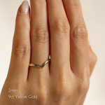 Hand wearing a 9ct yellow gold chevron wedding ring with '2mm' text on a neutral background