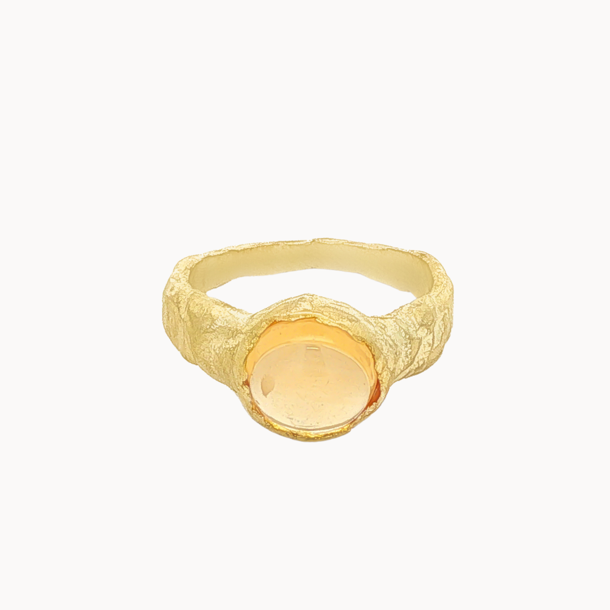 A textured gold signet ring with a smooth, oval, pale yellow gemstone, shown against a plain off-white background.