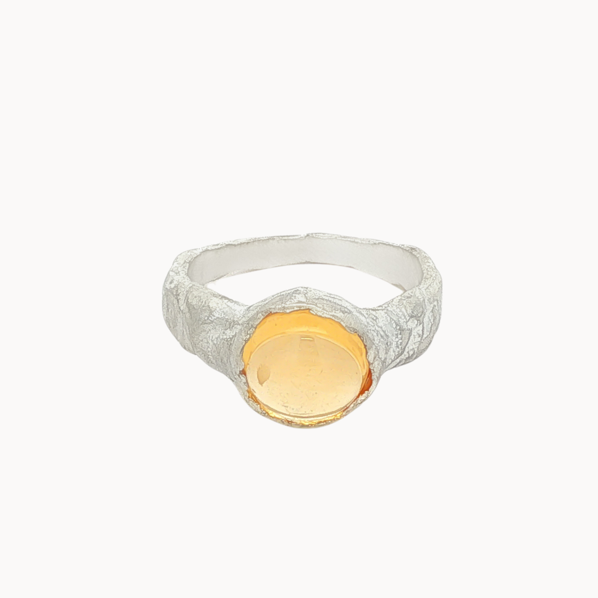 silver textured ring with round orange citrine gemstone on a white background