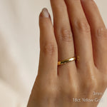 Gold ring with dainty hammered texture on a finger with '3mm 18ct Yellow Gold' text.