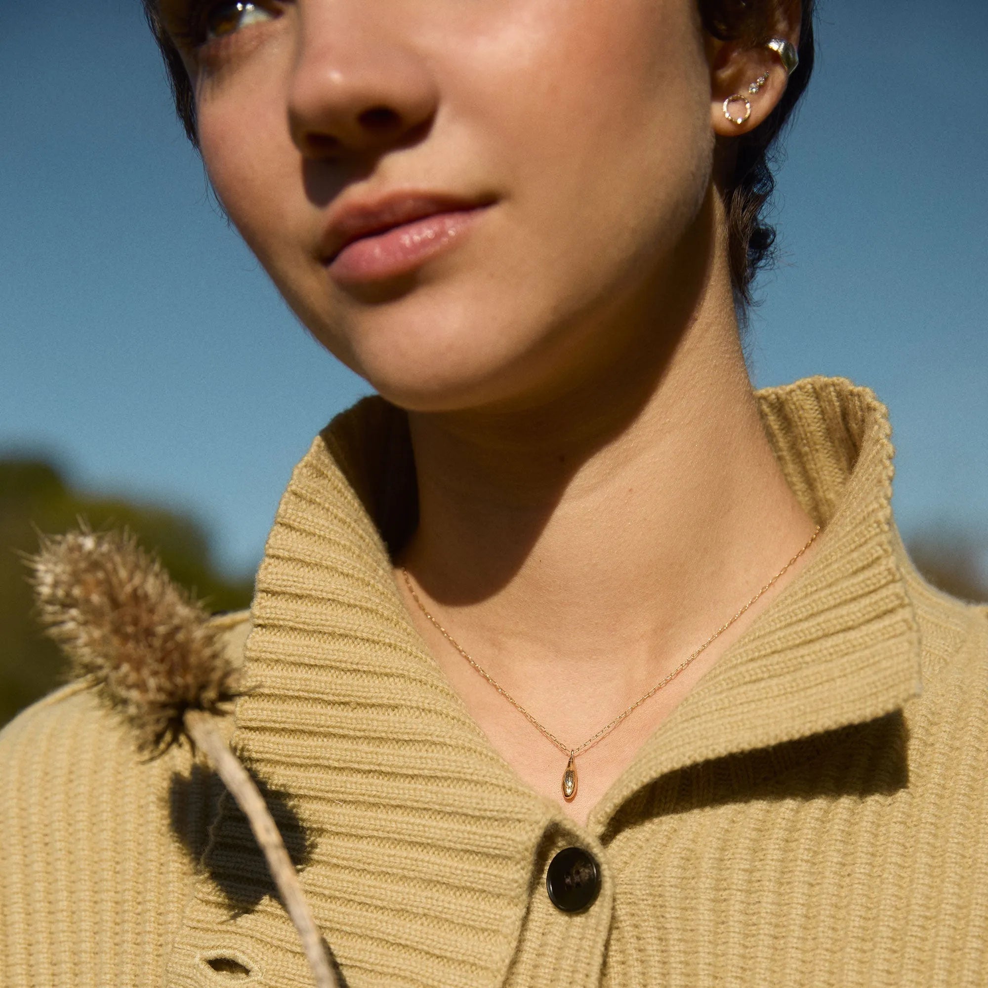 Person wearing a beige sweater with a blurred background