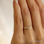 Gold v shaped wedding ring with diamonds on a hand, labeled '18ct Yellow Gold'.