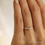 Gold v shaped wedding ring with diamonds on a hand, labeled '18ct Yellow Gold'.