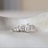 Diamond cluster engagement ring on a ceramic surface with a blurred background