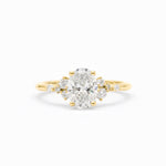 A yellow gold ring featuring a large oval-cut center diamond surrounded by smaller round diamonds on the shoulders, set against a clean white background.
