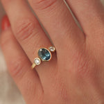 Gold ring with a blue gemstone on a hand