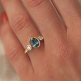 Gold ring with a blue gemstone on a hand