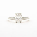 An oval-cut diamond solitaire ring in a four-prong setting on a polished silver-colored band, centered against a plain white background.