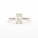 An oval-cut diamond solitaire ring in a four-prong setting on a polished silver-colored band, centered against a plain white background.