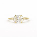 east-west set diamond engagement ring with oval diamond in gold on a white background