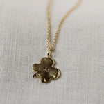 back of gold 4 leaf clover necklace with 'Find it' engraved