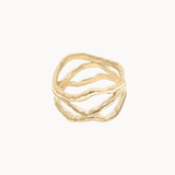 A gold-toned multi-band ring with a textured, organic wavy design, centered on a plain off-white background.