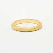 Gold frosted wedding ring on a white background