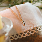 solid gold necklace with 7 pendant on lace fabric