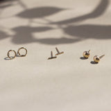 circle, bar and pebble gold stud earrings with leaf shadow