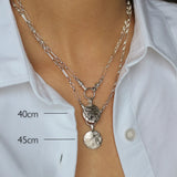 Silver necklace with pendant on a person wearing a white shirt, showing measurements.