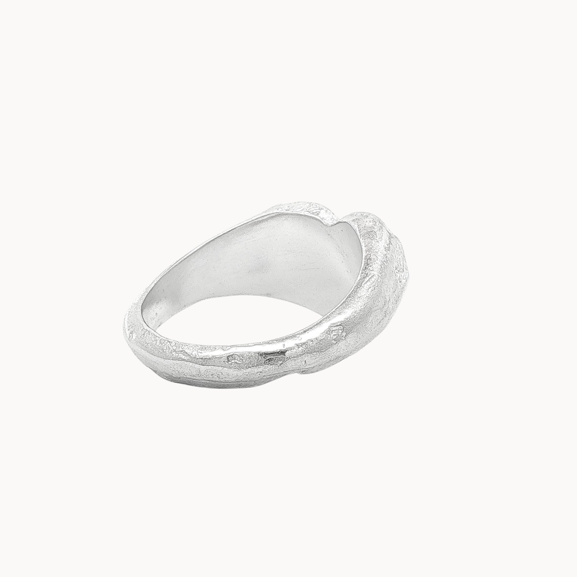 Back view of a textured sterling silver heart signet ring with a polished, organic finish, shown on a clean off-white background.