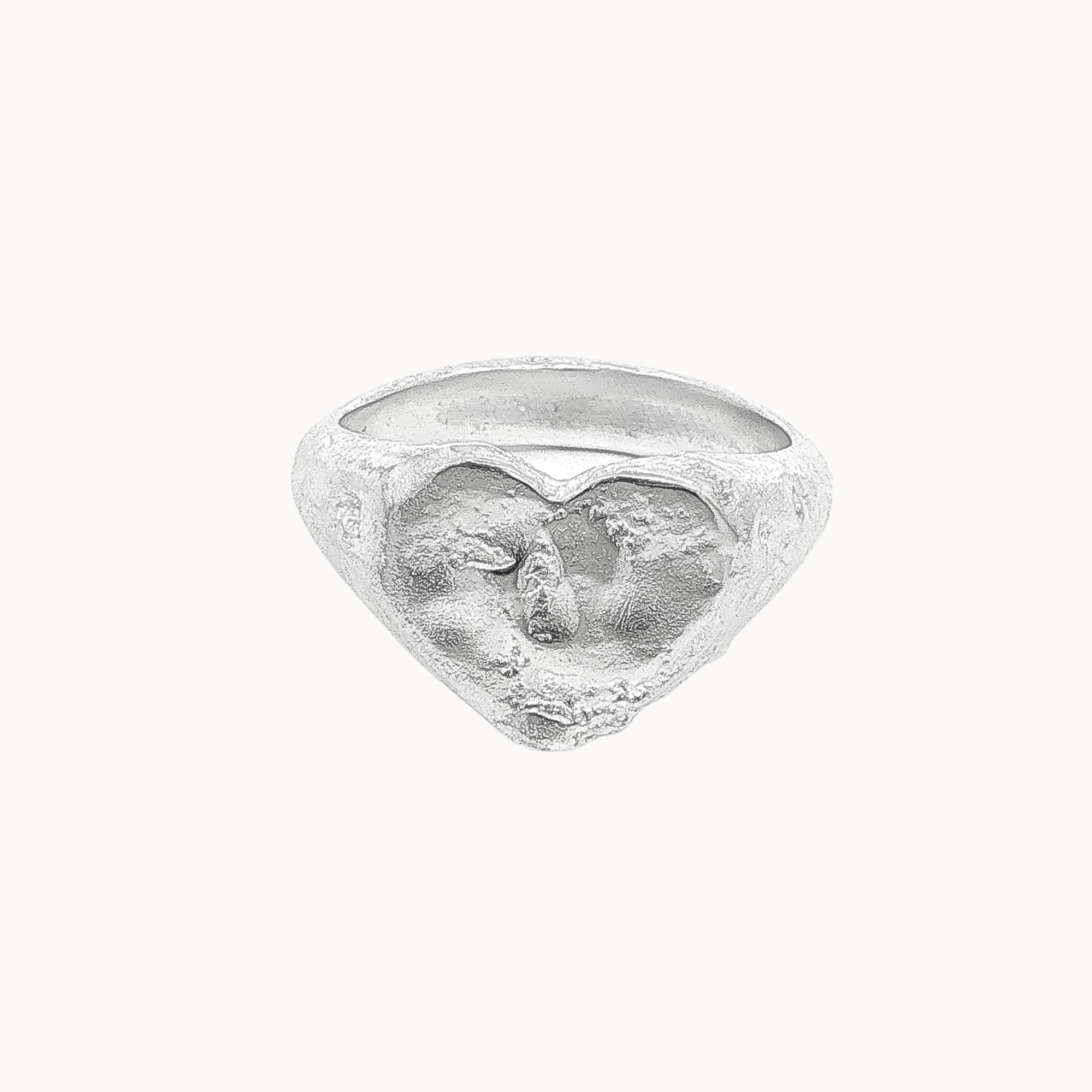 A textured sterling silver ring featuring a sculpted heart design and organic finish, photographed against a solid off-white background.