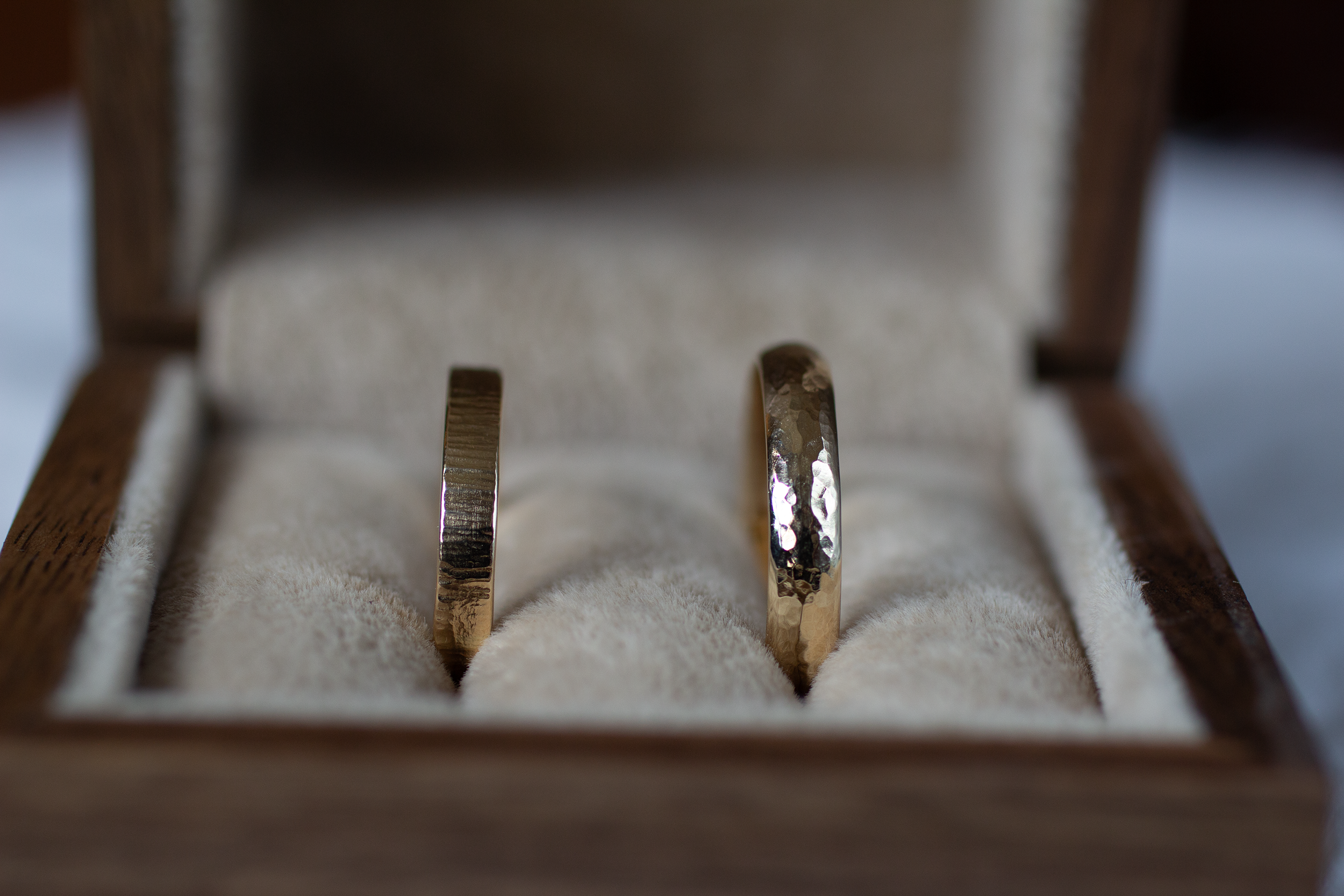 Two gold rings in a wooden box with a soft focus background