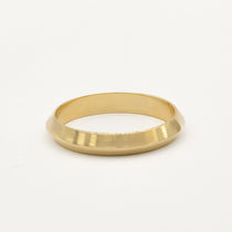Gold ring with softly pointed knife edge shape on a white background