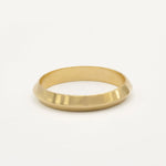 Gold ring with softly pointed knife edge shape on a white background
