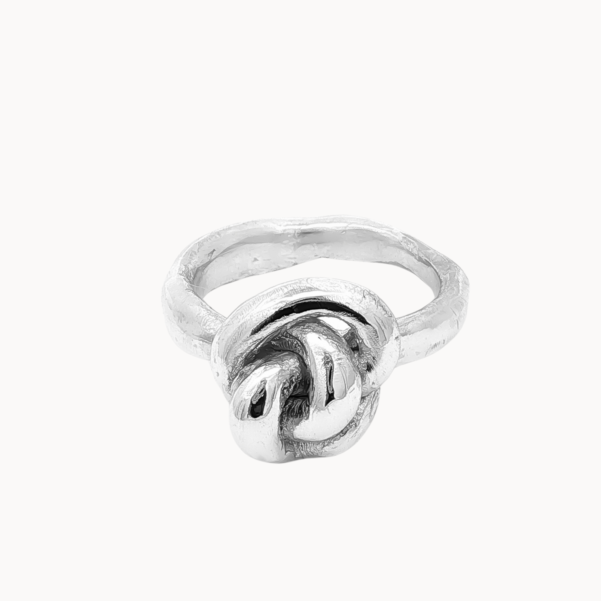 A sterling silver ring featuring a knotted design on the front, set against a plain off-white background.