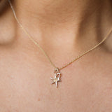 close up of person wearing a gold necklace with star and number '7' pendant on the same chain